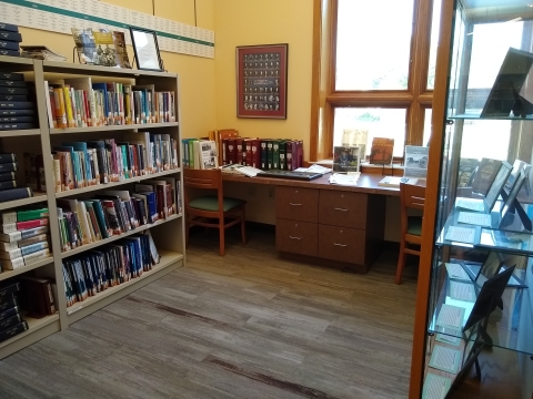 photo of the room including filled bookshelves, desks, and displayed photographs