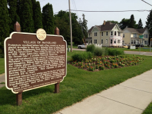 Village of McFarland sign, with Larson house in the background