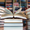 a stack of books. the top book is open and fanned out